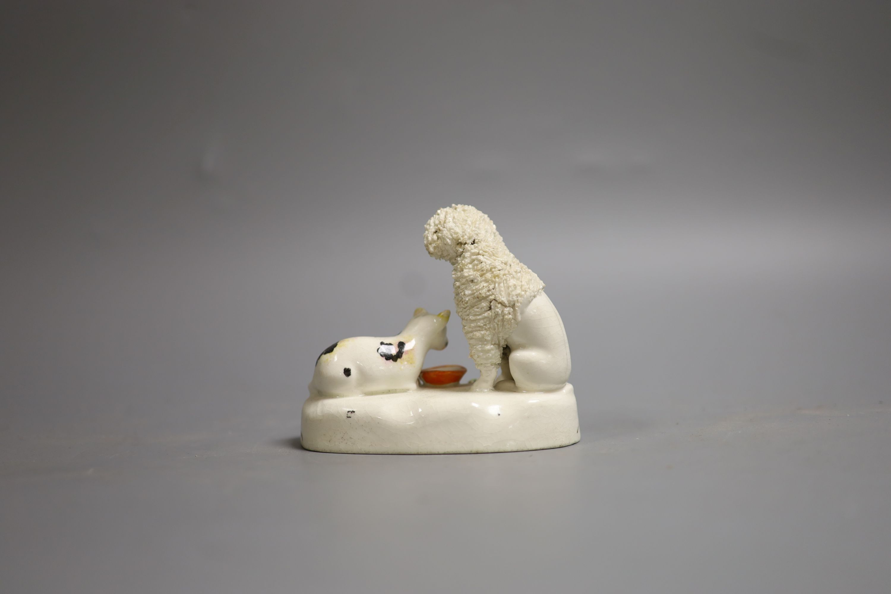 A Staffordshire porcelain group of a poodle and a cat, c.1830-50, 11 cm long